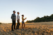 © Jordi Mora - Family with a plant while standing outdoors in the field at sunset.