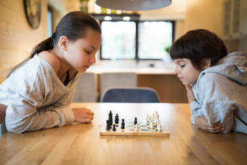 Wall Mural - Sister and brother playing chess at home