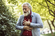 © ImageDesign - Mature age man showing strong signs of congestion or chest pains while walking in the park, warmly dressed for cooler weather. Developed with generative ai
