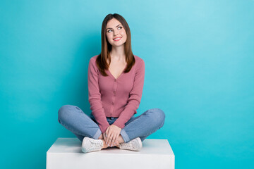 Wall Mural - Full length photo of satisfied woman wear trendy shirt denim pants look empty space sale sit on platform isolated on teal color background