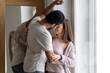 © Chiralli - Multiethnic American couple embracing at home.