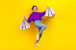 Leinwandbild Motiv Full length body photo of young carefree addicted shopaholic woman wear formal clothes hold bags boutique isolated on yellow background