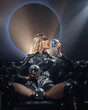 © Oleh - a girl in leather clothes on a leather sofa with artistic makeup on a background with a glowing circle with soap bubbles and a disco ball