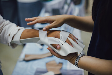 Therapist making asissistive device for immobilize patient hand. Splint service for hand injury rehabilitation of occupational therapy clinic.