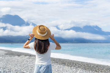 Poster - Woman with straw hat in the beach with clear blue sky