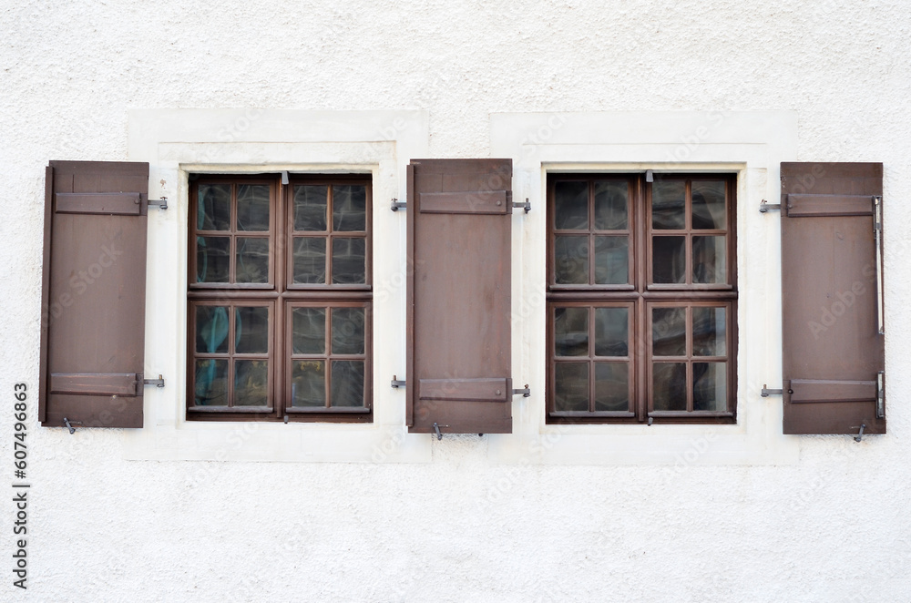 View of white building with wooden windows and shutters