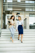 © BGStock72 - Two young business women walking on stairs in the office hallway