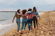© bernardbodo - Rare view of four young women walking together on beach