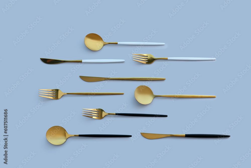 Golden cutlery on blue background