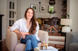 © sepy - Portrait of brunette haired young woman wearing casual clothes and relaxing in an armchair at home