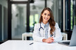 © bnenin - Portrait of a pretty female doctor sitting at the office table and working on a laptop.