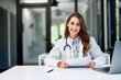 © bnenin - Portrait of a beautiful female doctor doing paperwork at the office table.
