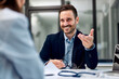 © bnenin - A smiling businessman in a suit talking with a female doctor at the office.