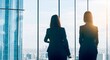 Back view of female colleagues in formal wear standing near window looking at modern exterior of skyscrapers in business center, silhouette of women together planning future success, generative ai