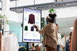 © DC Studio - Customer using touch display shopping for fashion items in clothing store, interactive board. African american man choosing stylish clothes with different designs, modern kiosk service.
