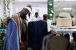 © DC Studio - Buyer deciding between two jackets while choosing formal wear in clothing store. African american man holding blazers on hangers while examining style and fabric in shopping center