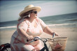 Curvy, plus size, active, big, chubby woman riding a bike on the beach. Generative AI.