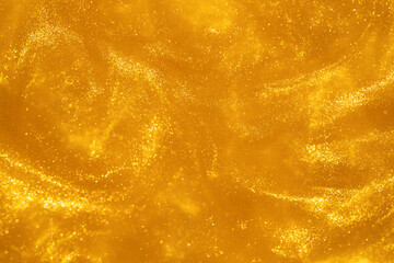 Atmospheric whirlwind of gold particles in fluid. Countless glistering sparkling particles in golden liquid. Abstract Blazing background with golden dust glitters.