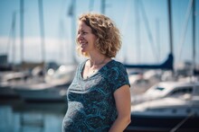 Portrait Of A Beautiful Pregnant Woman On The Pier With Boats.