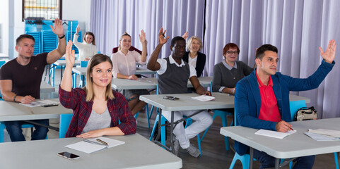 Wall Mural - Portrait of multinational student group with hands raised during lesson in auditorium