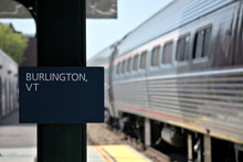 Train Stopped At Platform In Burlington, Vermont (sign On Post With Train In Background)