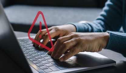 Human use laptop with red triangle caution warning sign for notification error, programmer, hacked alert, cyberattack, hacker, malware, danger, cyber crime, internet web hack technology