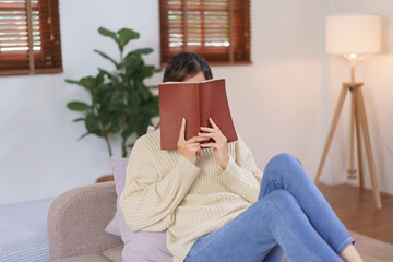 Wall Mural - Relaxing time concept, Woman use holy bible covering face while reading book at modern home office