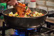 French cuisine ratatouille salad shchef stirs in frying pan on gas stove