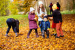 © oksix - Group of friends play in autumn park