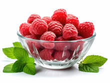 Glass Bowl With Raspberries And Green Leaves On A White Background
