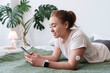 © Westend61 - Woman with diabetes using smart phone lying on bed at home