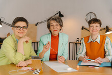 Three Business Women Siting At Table Looking At Camera