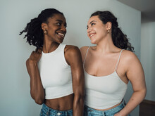 Happy Young Multiracial Friends Standing Near Wall At Home