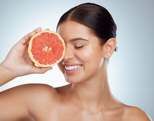 Poster - Face smile, skincare and woman with grapefruit in studio isolated on a white background. Vegan, natural and female model with fruit for vitamin c, nutrition or healthy diet, wellness or cosmetics.