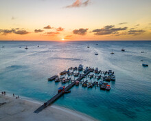 Aerial View Of Boats Moored At The Pier On The Beach Along The Coastline At Sunset In Noord, Aruba.