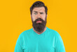 © be free - portrait of puzzled bearded man isolated on yellow studio background