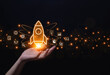 © VRVIRUS - hand Shows a rocket and an icon. Concept of Startup Business, Entrepreneurship Idea, and Online Digital Business.