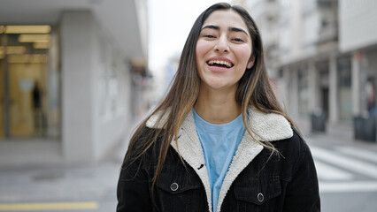 Wall Mural - Young beautiful hispanic woman smiling confident standing at street