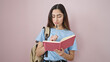 © Krakenimages.com - Young beautiful hispanic woman student writing on notebook over isolated pink background