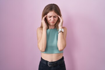 Canvas Print - Blonde caucasian woman standing over pink background with hand on head, headache because stress. suffering migraine.