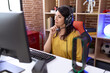 © Krakenimages.com - Middle age hispanic woman playing video games using headphones serious face thinking about question with hand on chin, thoughtful about confusing idea