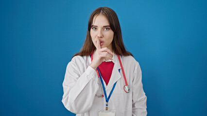 Poster - Young hispanic woman doctor asking for silent over isolated blue background