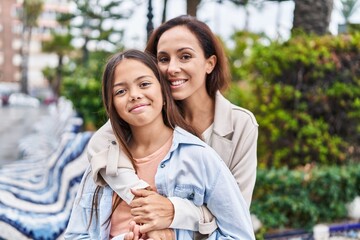 Sticker - Woman and girl mother and daughter hugging each other at park