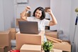 © Krakenimages.com - Young woman smiling confident using laptop at new home
