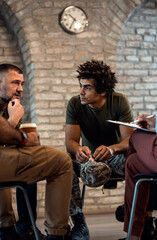 Wall Mural - Group of diverse veterans talking during PTSD support group.