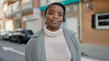 Wall Mural - African american woman standing with relaxed expression at street