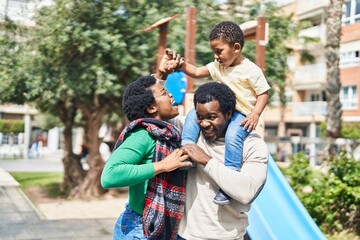 Wall Mural - African american family holding boy on shoulders at playground