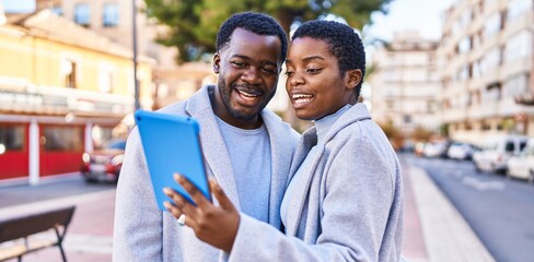 Canvas Print - Man and woman couple having video call by touchpad at street