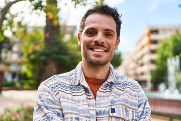 Wall Mural - Young hispanic man smiling confident standing at park