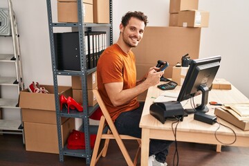 Canvas Print - Young hispanic man ecommerce business worker using smartphone working at office